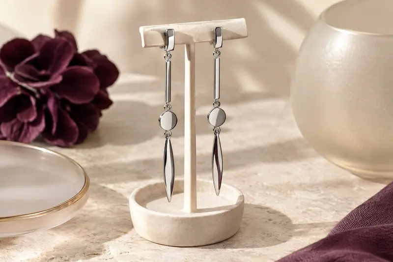 Boucles d’oreilles pendantes en acier inoxydable sur fond crème