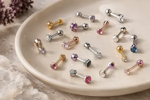 Assortiment de labrets à zircone sur une surface claire, avec leurs tiges droites et leurs fermetures à vis