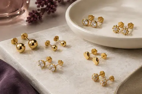 Assortiment de puces d’oreilles dorées à billes et à éléments CZ sur une pierre claire