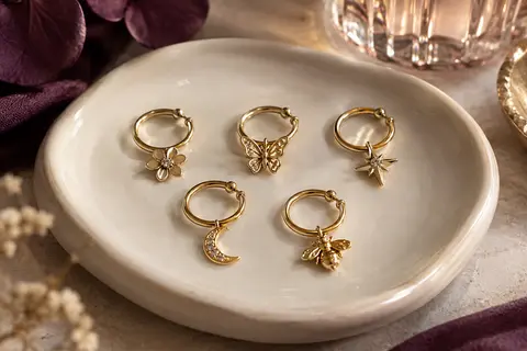 Assortiment d’anneaux de nez dorés Dochais aux motifs de fleur, papillon, étoile, lune et abeille.