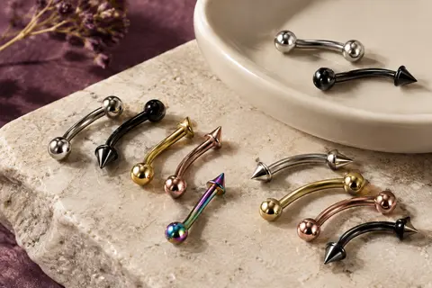 Assortiment de barbells courbes aux embouts demi-boule et demi-pointe sur une pierre claire