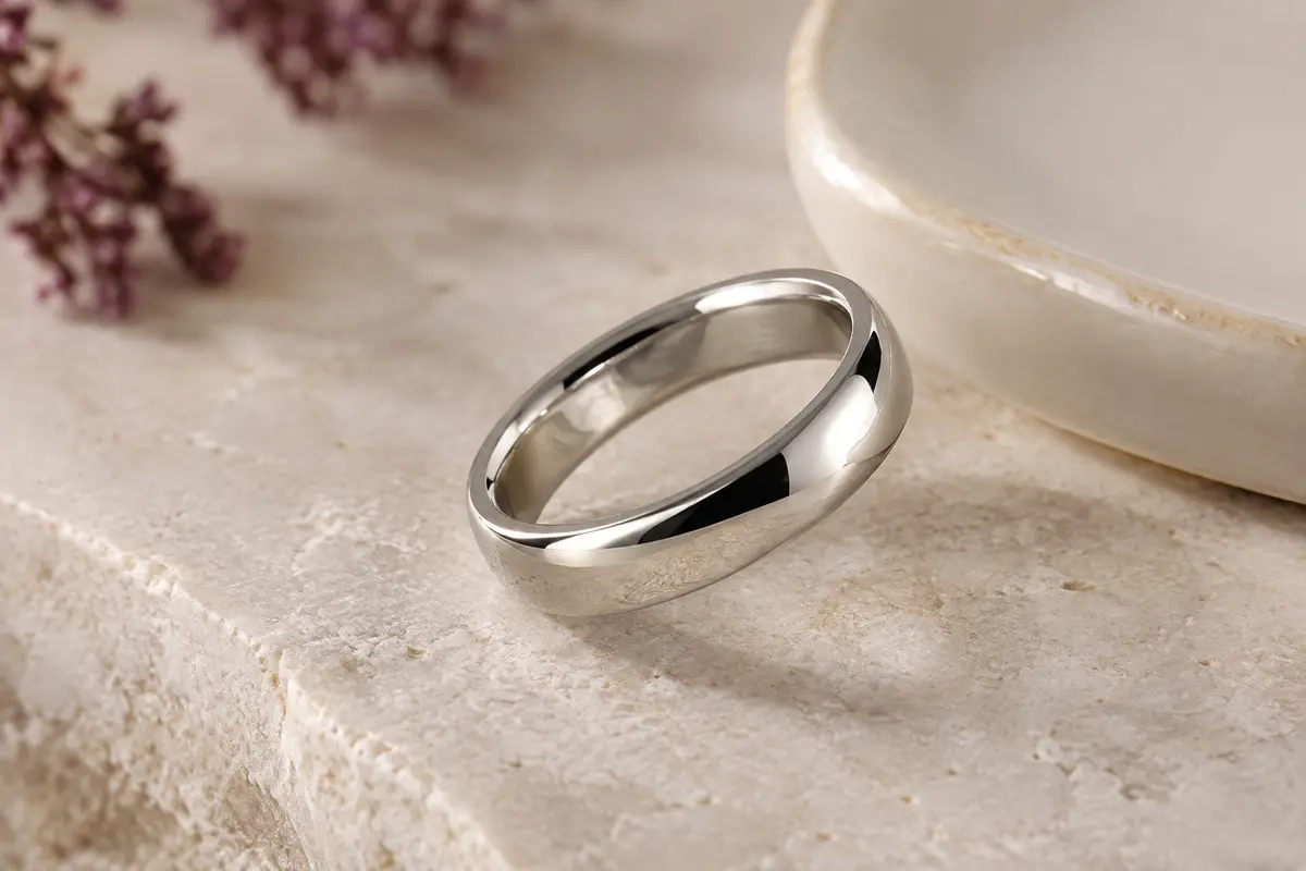 Bague alliance argentée en acier, avec anneau lisse de 6 mm et bords arrondis sur une pierre claire