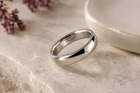 Bague alliance argentée en acier, avec anneau lisse de 6 mm et bords arrondis sur une pierre claire