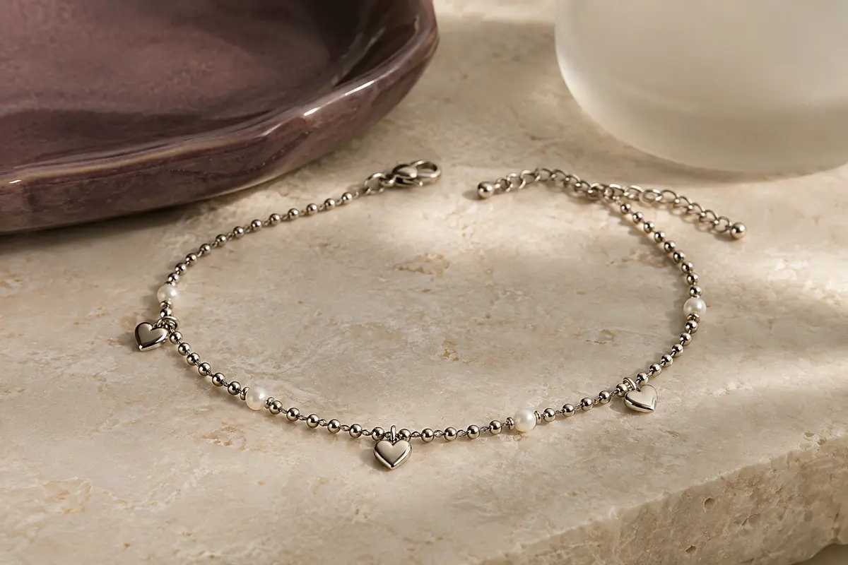 Bracelet de cheville argenté à chaîne perlée, motif cœur et fermoir mousqueton sur pierre claire